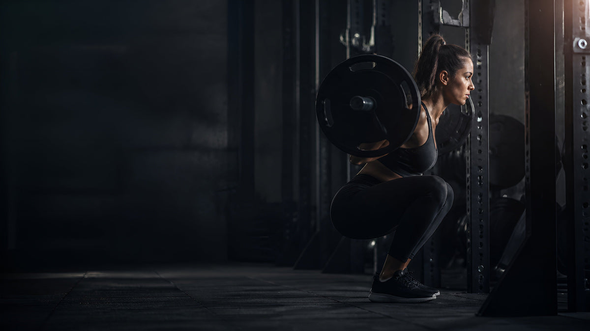 Atleta entrenando sentadilla en un rack de gimnasio